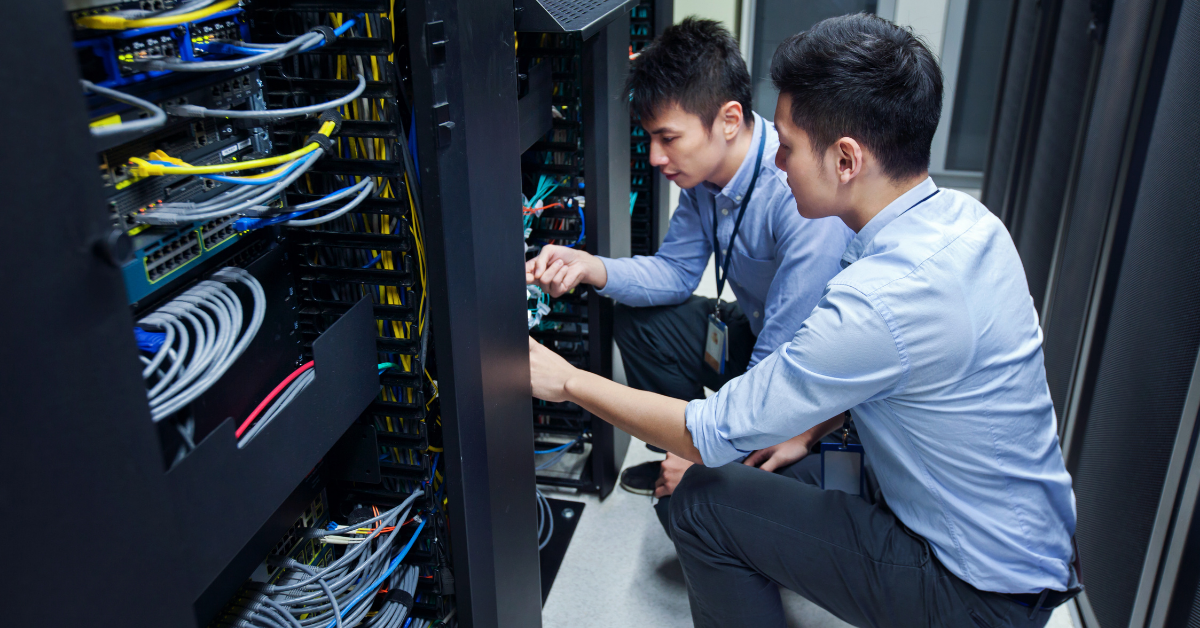 two IT male employees working on network server